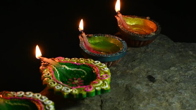 happy diwali many terracotta diya or oil lamps arranged over clay surface or ground in one line or curved or zigzag form