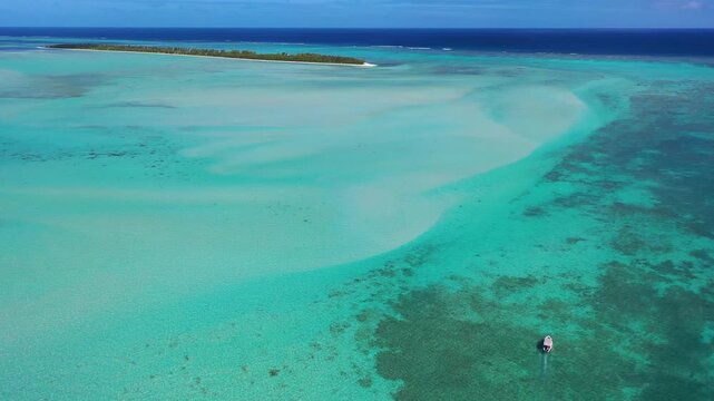 Small boat cruising over shallow sea in Indian Ocean