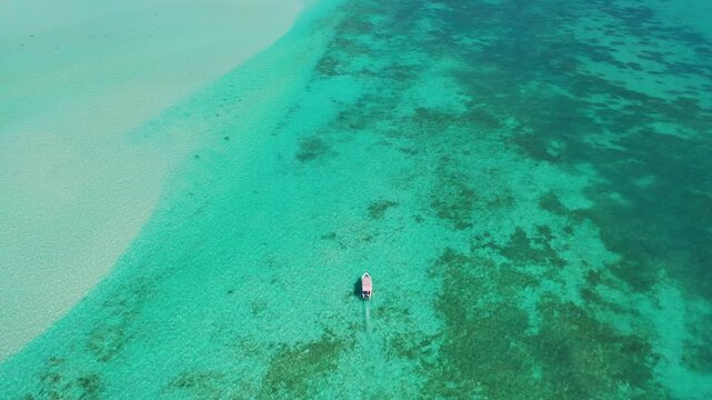 Small boat cruising over shallow sea in Indian Ocean