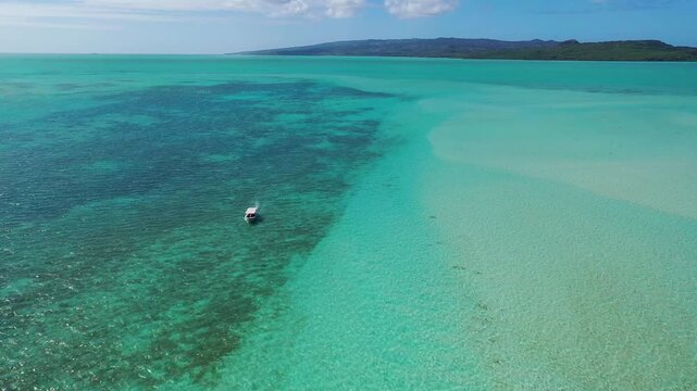 Small boat cruising over shallow sea in Indian Ocean
