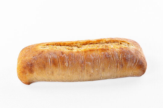 Golden crust loaf with flour dusting and scored top, artisan bread on white background