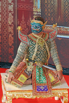 Majestic giant character Kumbhakarna posing on stage in elaborate handwoven golden costume, classical Thai KHON dance performance