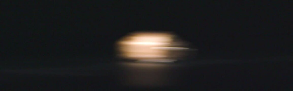 Abstract anamorphic bokeh lights with defocused lepidolite mineral on black background