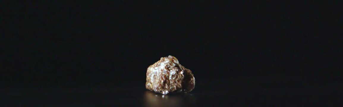 Macro shot of rotating lepidolite mineral on black background