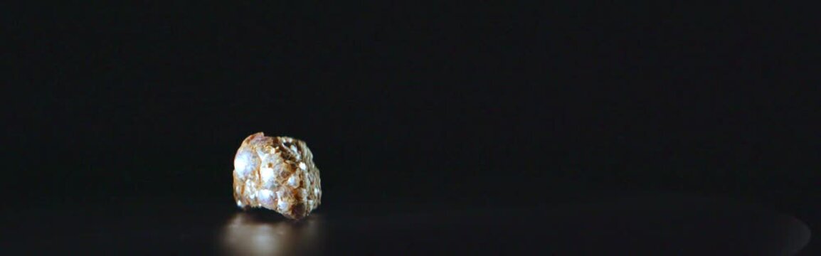 Anamorphic lepidolite mineral rotating on black background