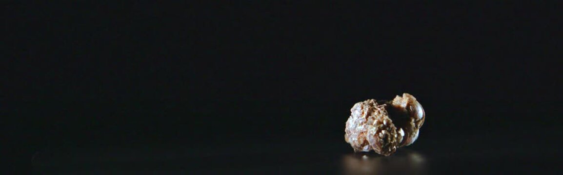 Close up of lepidolite lithium mineral rotating on black background