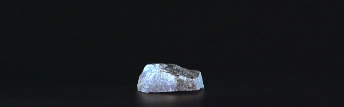 Macro view of purple lepidolite rotating on black background