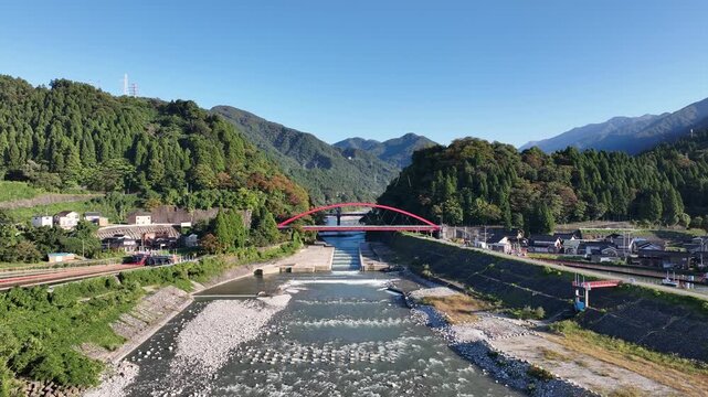 季節は秋、日本の富山県黒部川に架かる赤い愛本橋
