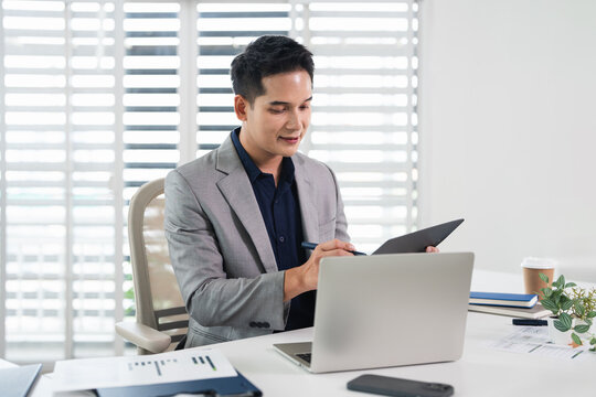 A businessman is working in modern office, reviewing documents . Focused and professional.