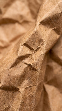 Crumpled paper texture abstract background, natural beige wrinkled surface, organic brown material close-up copy space