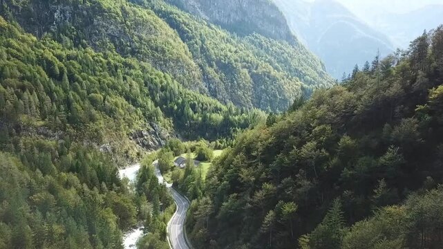 Drone flying right to left across the Soča valley with the river and a road, beautiful mountains, Slovenia