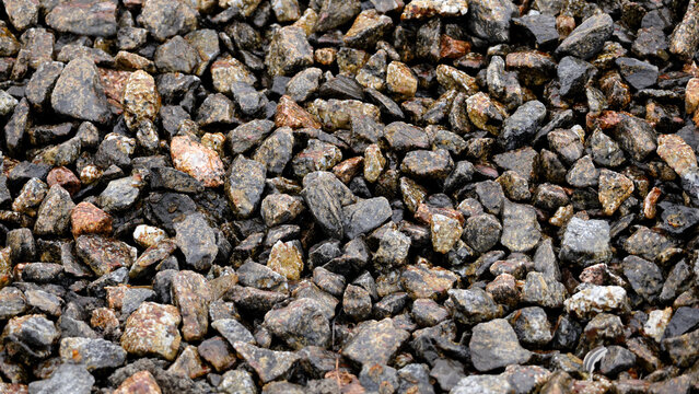 Wet dark crushed stone gravel texture background
