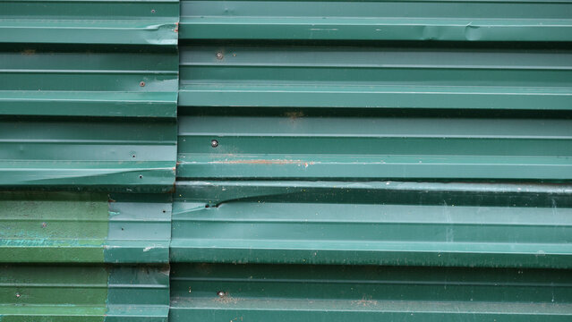 Green corrugated metal fence texture background