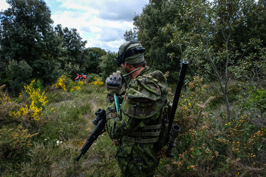 Airsoft player crossing open ground between two woods during a twenty four hour war game near Carcassonne, France