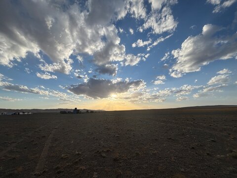 Sun Rays Illuminate the Horizon beneath Dramatic Evening Clouds