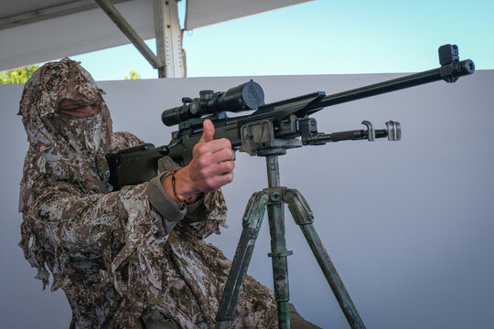 Marksman in a camouflage suit on his tripod during a demonstration at a defence trade fair near Paris, France