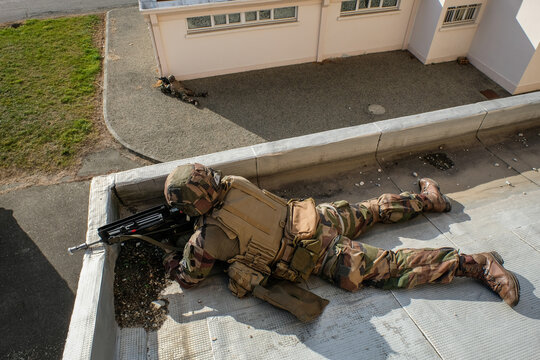Foreign Legion paratrooper taking up a firing position on the edge of a roof during training in Toulouse, France