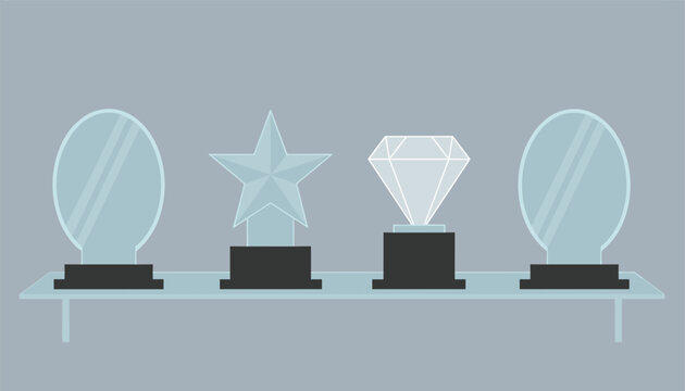 Glass and crystal awards and trophies displayed on a modern floating shelf against a grey wall.