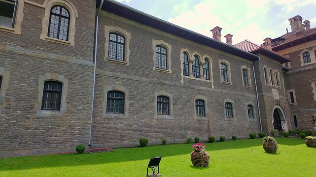 Long stone facade with rows of arched windows at Cantacuzino Castle in Busteni Romania
