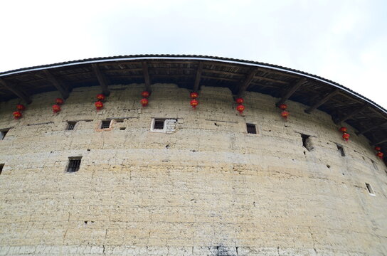 Round earthen wall of a tulou with red lanterns in Fujian China