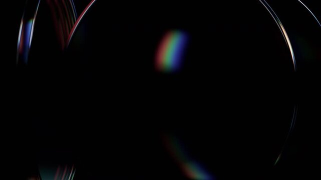 Rotating round transparent glass discs with iridescent rainbow edges on a dark black background, seamless loop, 3d rendered animation