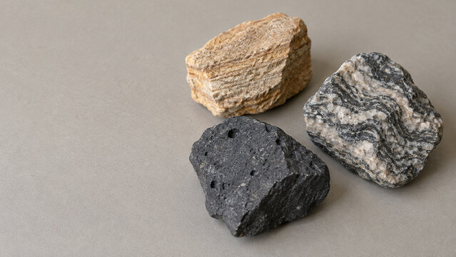 Three geological rock specimens on a table with copy space