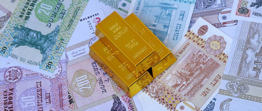 Moldovan leu money bills and gold bullion bars. Moldova cash bills of MDL currency close up