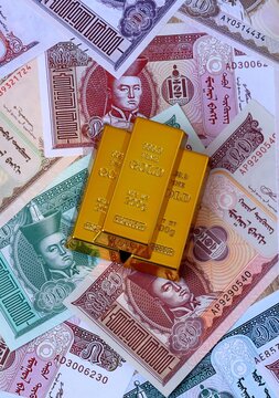Mongolian tugrik money bills and gold bullion bars. Mongolia cash bills of MNT currency close up