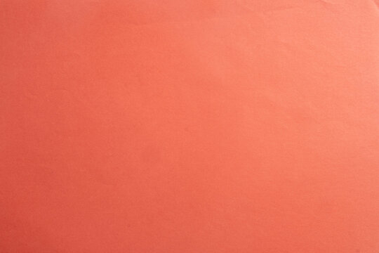 Close up of coral red or salmon pink paper texture background. Concept for blank empty space, pastel color template, and abstract minimal backdrop for graphic design.