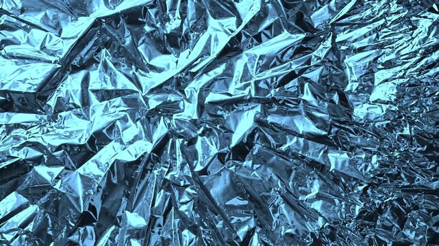 Abstract blue foil texture with metallic crumpled surface. Wrinkled blue foil reflects cool light creating dark shadows. Decorative shiny material for creative modern design or background.