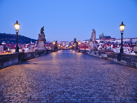 Charles Bridge lamps and statues at blue hour in Prague