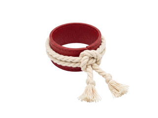 Red leather cuff bracelet with decorative white rope knot and tassels on transparent background © ieps
