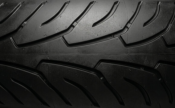 Close-up of a large motorcycle tire with deep tread patterns, rugged rubber texture, sharp grooves, and heavy-duty grip design. Ideal for automotive backgrounds and industrial use.