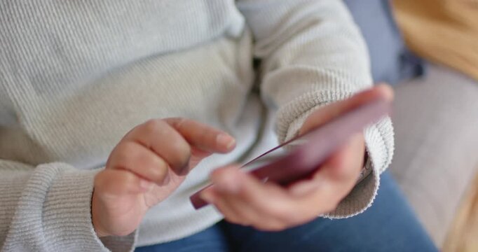 Left hand is cradling pink phone while right index finger is tapping and swiping to browse