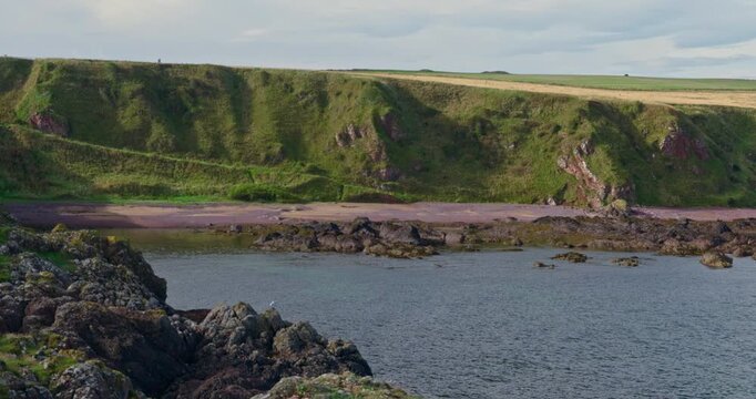 Rugged Coastal Cliffs and Rocky Shoreline with sandy beach in Eyemouth