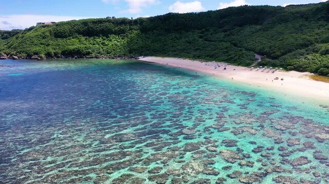 Yoshino Beach and coral reef beside green hills Miyakojima Japan