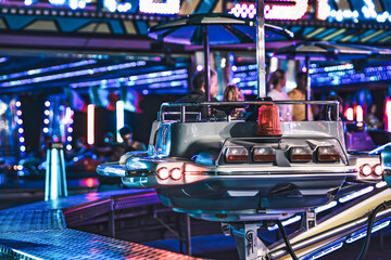 Retro spaceship ride spinning at amusement park with blurred people in background © Filipo