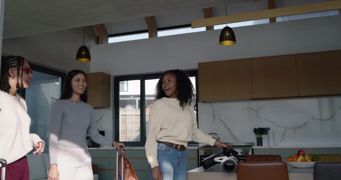 Three African American women arriving with suitcases and yoga mat, exploring modern rental patio