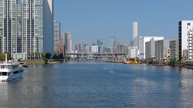 運河にかかる橋とビル群が見える都市の風景。