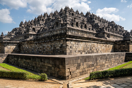 Ancient stone stupas and architecture of Borobudur Buddhist temple under blue sky in Central Java, Indonesia
