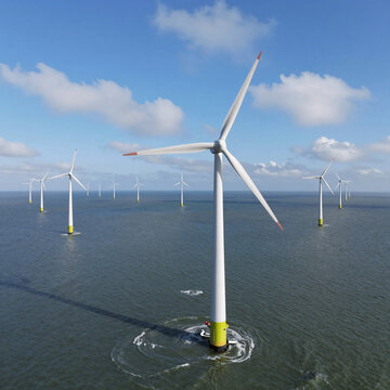 Dramatic Lighting Sky Netherlands. Aerial View Of Windmill Park In The Ijsselmeer, Netherlands, Showcasing Green Energy With Turbines Amidst Clouds And A Blue Sky