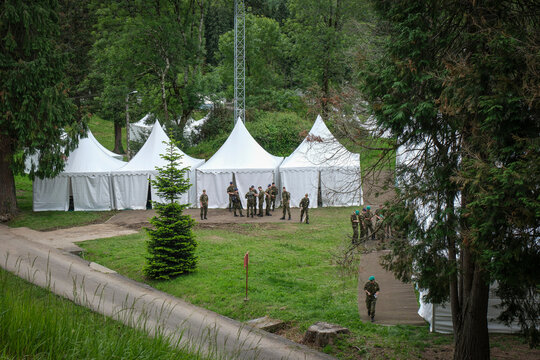 White tents pitched in a meadow for soldiers attending the military pilgrimage in Lourdes, France