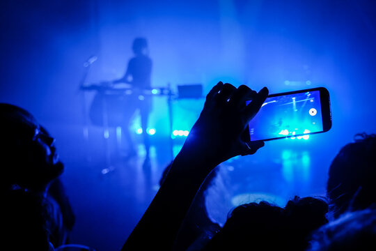 Phone raised above the crowd at an electronic music concert in Toulouse, France