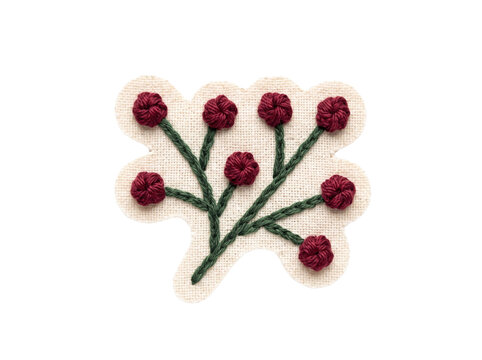Handmade embroidery patch featuring a floral branch design with dark red knots on beige fabric