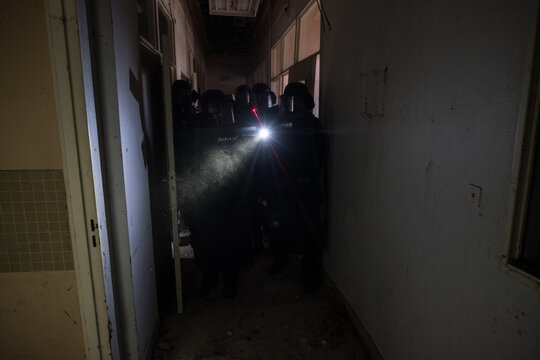 Single flashlight beam at the end of a dark corridor during a French police tactical unit drill in Toulouse, France