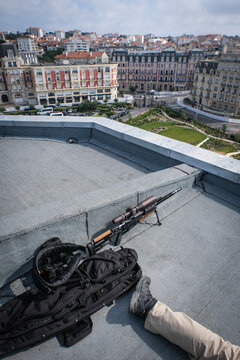 Police marksman rifle resting while the observer works on a rooftop during summit security in Biarritz, France