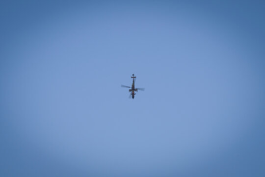 Military attack helicopter hanging alone in the blue sky during a flying display at Le Bourget, Paris, France