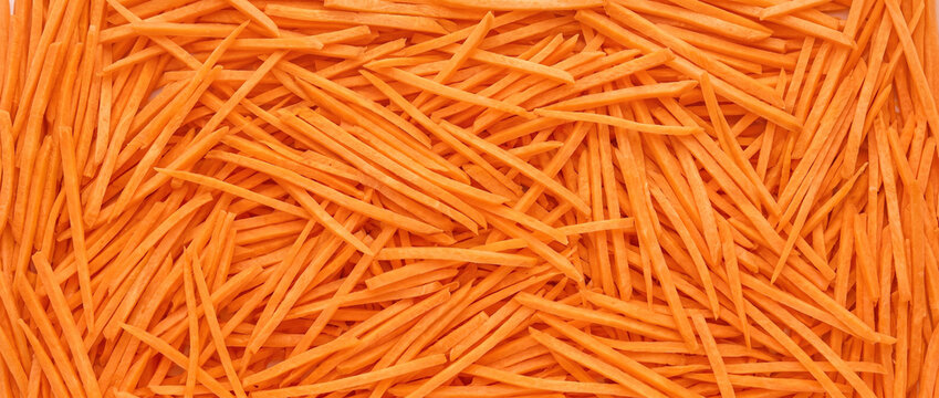 Fine julienned carrot field with slender orange strips densely overlapping in a directional fresh vegetable pattern