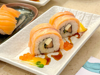 Sushi roll with salmon and avocado on white plate © Denwisit