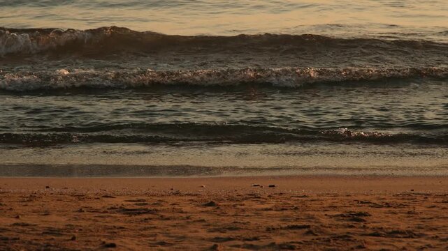 Beautiful coastal sunset with waves washing ashore